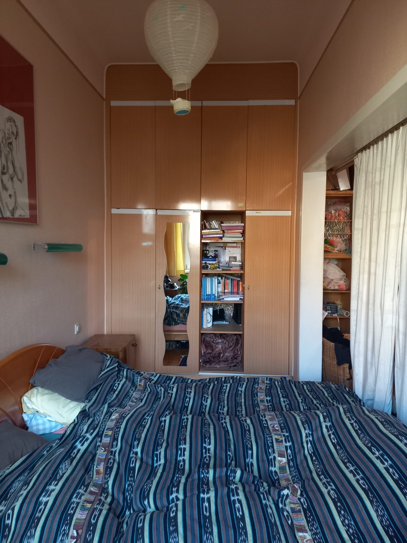 Nachher rechte Seite Schlafzimmer mit einem großen Bett, einem Kleiderschrank und Regal im Hintergrund.
